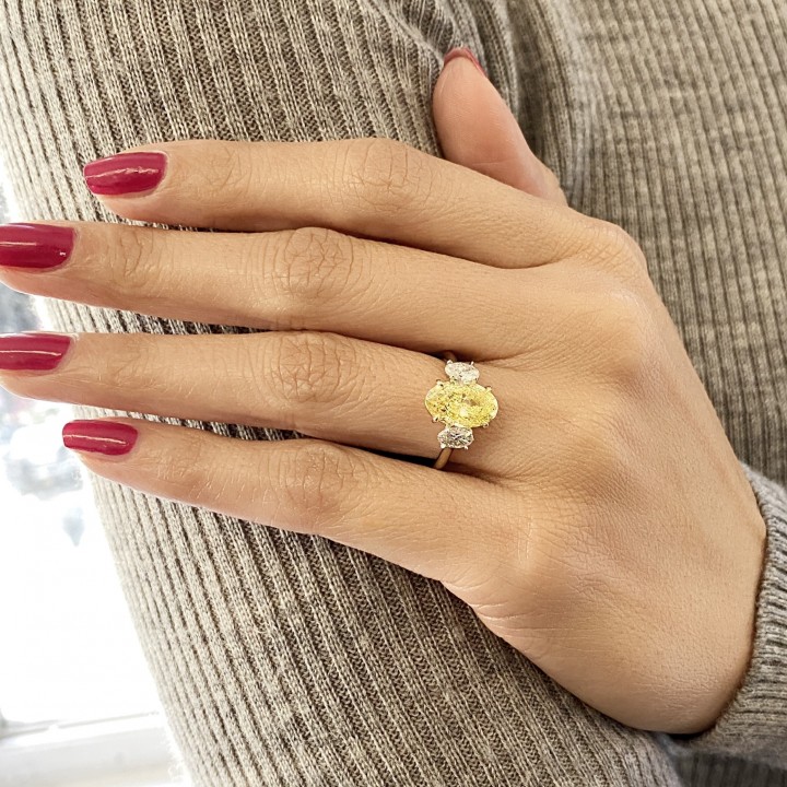 3.01 carat Fancy Intense Yellow Oval Diamond Three-Stone Ring flat